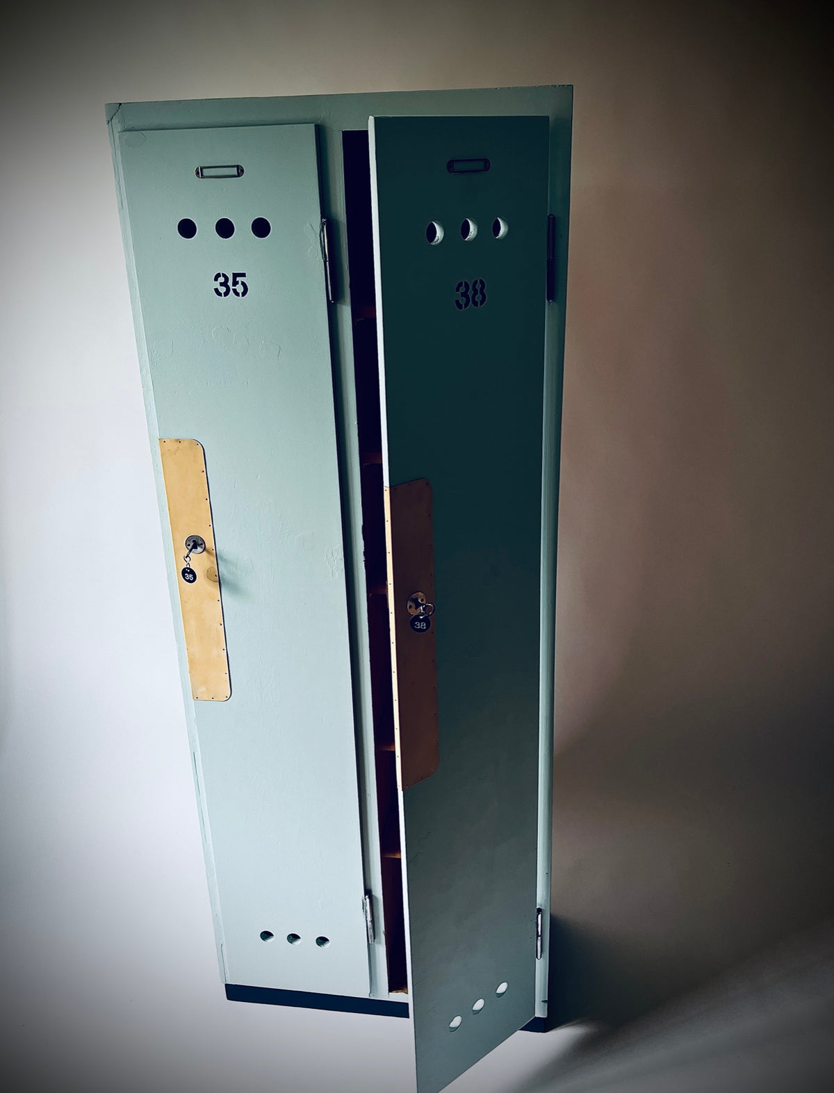 Garderobenschrank 35/38 mit teilweise geöffneter rechter Tür und dunklem Sockel.